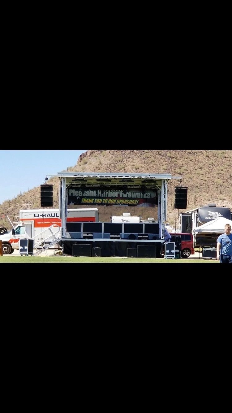 Mobile stage set up outdoors with line array speakers